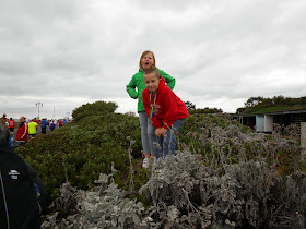 boy and girl standin on wall in bush