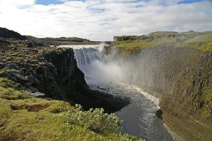 The waterfall Dettifoss is located in Vatnajökull National Park in Northeast Iceland, and reputed to be the most powerful waterfall in Europe. It is also the largest waterfall in Europe in terms of volume discharge, having an average water flow of 193 cubic meter per second. Its volume often increases, especially when the weather or volcanic activity prompts glacial melting on the Vatnajokull glacier icecap. The waterfall is so powerful that it makes the surrounding rocks vibrate, the vibrations can be felt by hand.