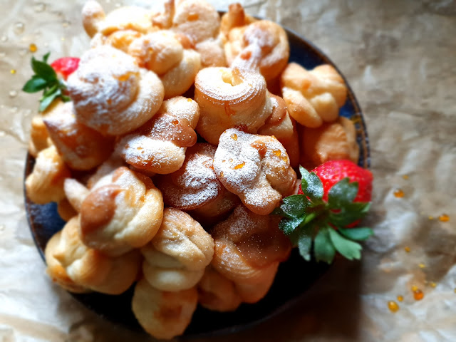 plate of croquembouche filled with dulce de leche and dusted with icing sugar