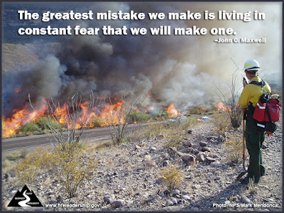 The greatest mistake we make is living in constant fear that we will make one. –John C. Maxwell (Wildland firefighter monitoring a fire along a road)