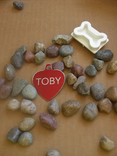 Picture of the things I was going to put on the stone - Toby's red name tag, some small rocks and the dog bone stamp