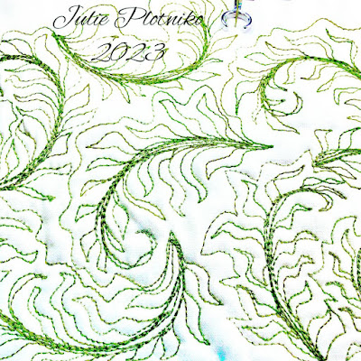 Machine stitching of green ferns on white fabric