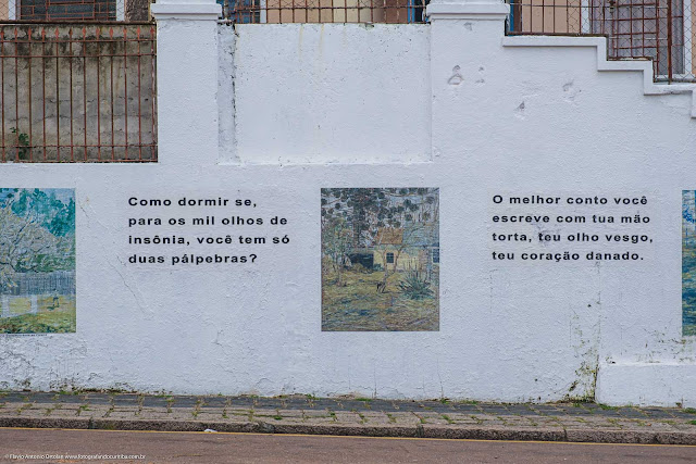 Muro com reproduções de pinturas de Miguel Bakun e textos de Dalton Trevisan