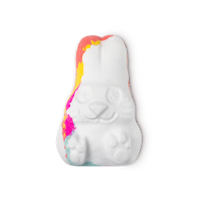 A white bunny shaped bath bomb with splashes of pink blue and orange on it on a bright background