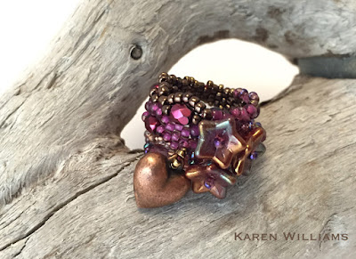 Be Mine freeform peyote ring by Karen Williams with three bellflower pressed glass beads and a puffed heart charm