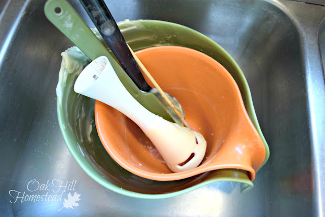 Washing up the bowls and equipment after making soap.