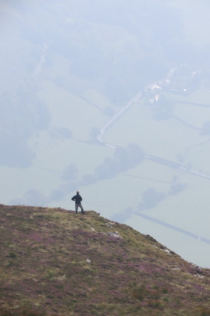 A walker standing overlooking the valley below.