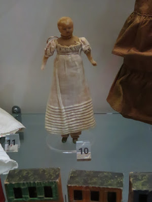 old doll wearing empire waist dress