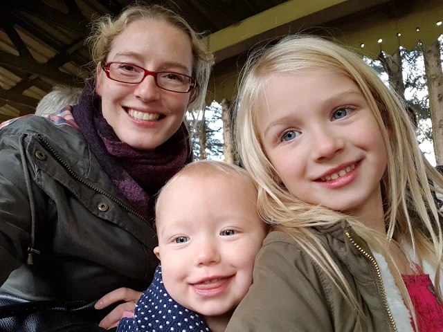 Me, Little and Big Sister sitting on a miniature train pulling cheesy grins for the camera