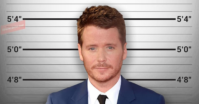 Kevin Connolly posing in front of a height chart background
