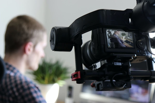 cameraman holding and filming a person