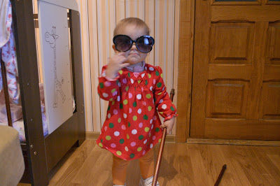 young girl playing with stick and sunglasses on