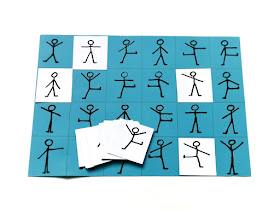 na zdjęciu niebieska plansza a4 z narysowanymi ludzikami w różnych pozycjach a na niej kilka kartoników w kolorze białym z ludzikami dopasowanymi do tych na niebieskiej planszy