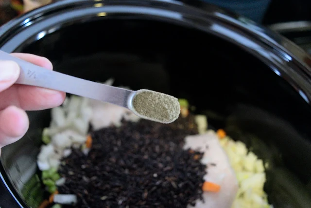 Ground sage being added to the crock pot.