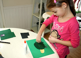 Tessa first chose a piece of glittery stiffened felt from a stack of differently textured fabrics. It reminded her of Speedy, a box turtle that we housed once for a local turtle race. After adding a head and legs cut from card stock, she drew shapes on its shell.