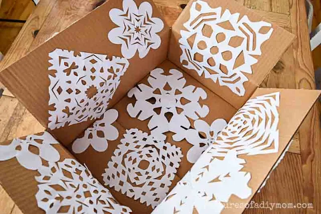 box with paper snowflakes on inside