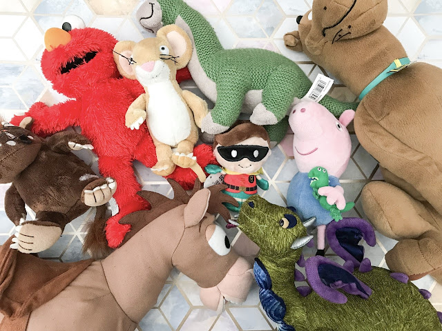 Flatlay showing lots of soft toys needing storage including The Gruffalo, Elmo, Bullseye, Scooby Doo and a dinosaur