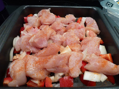 raw chicken bacon and veg on a baking tray