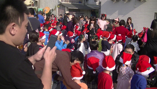 聖誕派對嗨翻天！高雄楠梓區童心園幼兒園老師以聖誕歌曲開場暖身，帶著家長寶貝帶動唱。