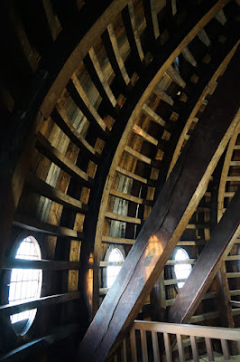 Section of the dome interior, with much woodword, and circular windows low on the walls.