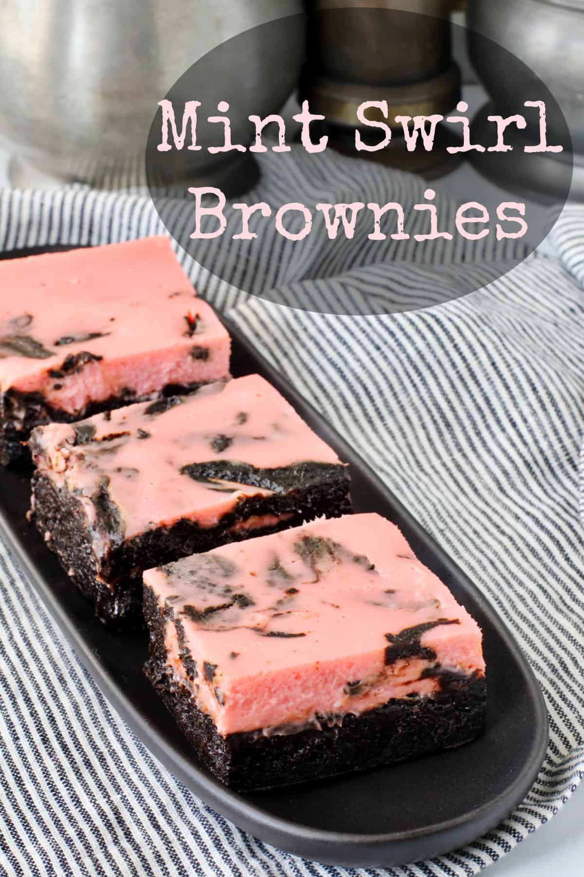 Peppermint Cheesecake Swirl Brownies on a black plate.