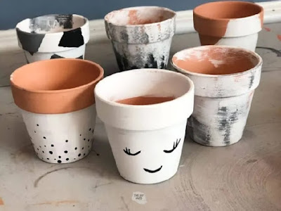 Terracotta flowerpots painted with black, grey, and white designs