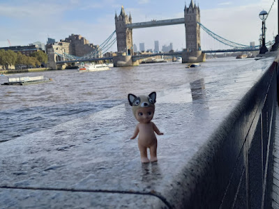 Rocky  op een muurtje langs de Theems, op de achtergrond de Tower Bridge