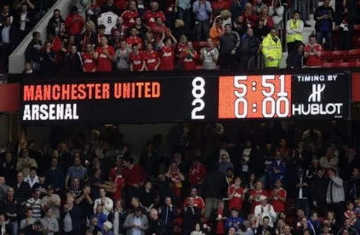 The scoreboard displays the 8-2 score-line during a match between Manchester United and Arsenal