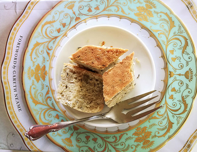 The Official Downton abbey cookbook with a plate of diamond shaped pieces of caraway seed cake