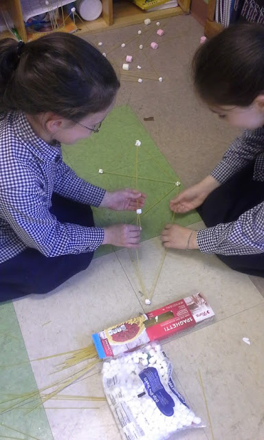 Two girls are working together to build their tower.