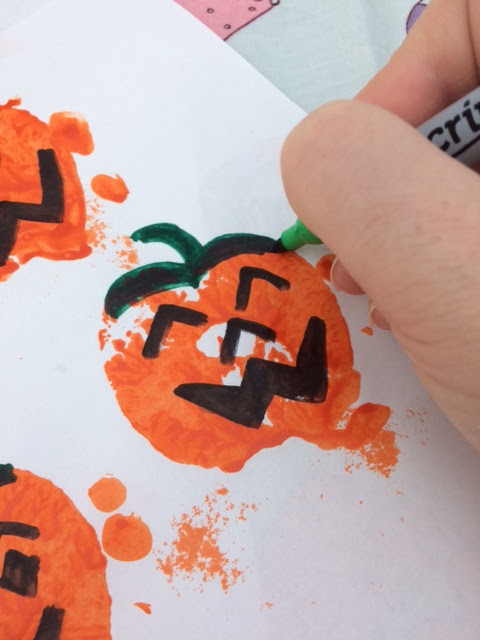 Pumpkin picture with a hand holding a pen and drawing on the stalk 