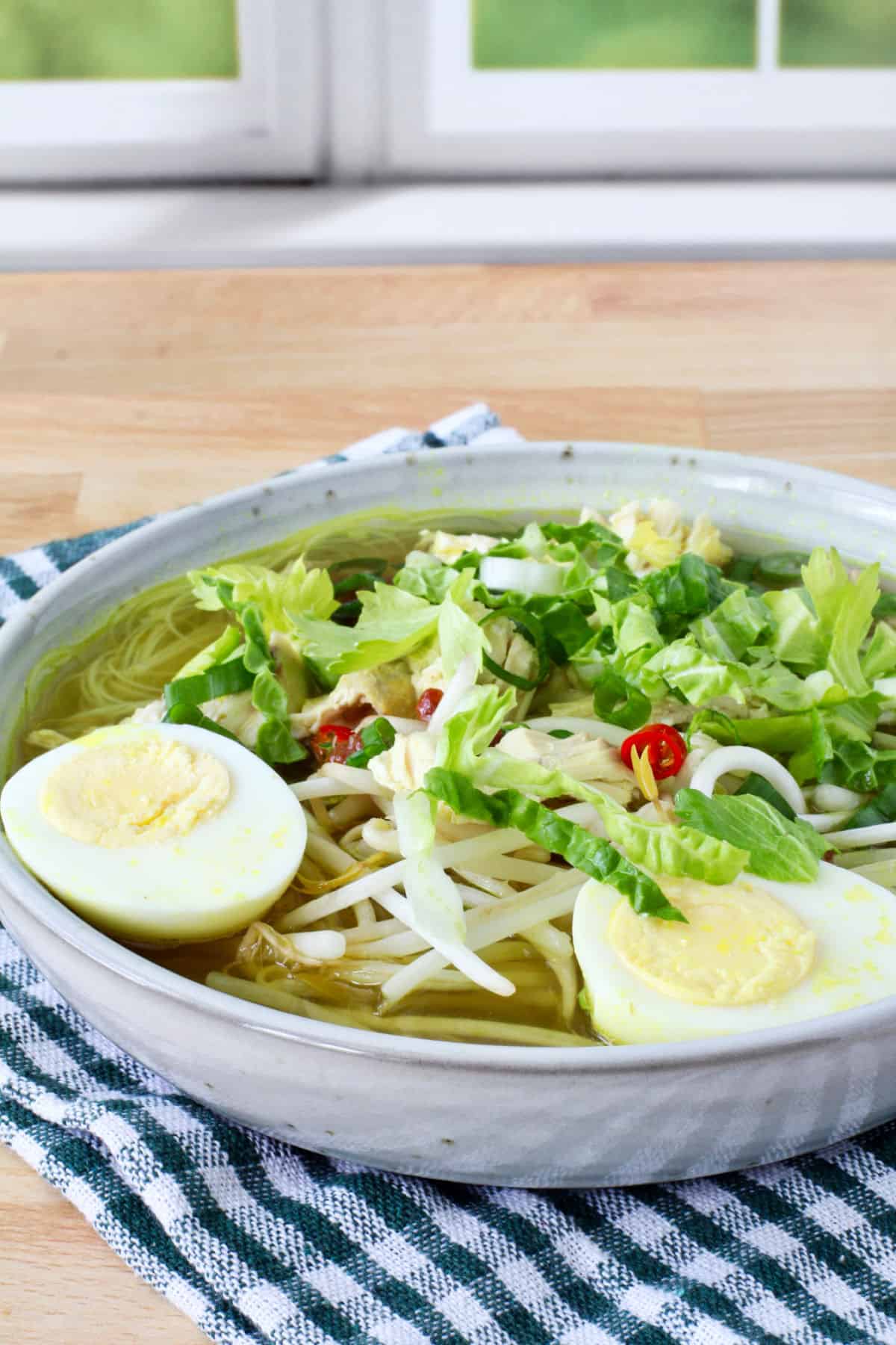 Soto Ayam (Indonesian-Style Chicken Noodle Soup) in a bowl with garnishes.