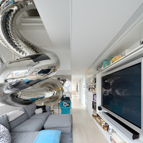 Living room with mirrored stainless steel slide and huge tv