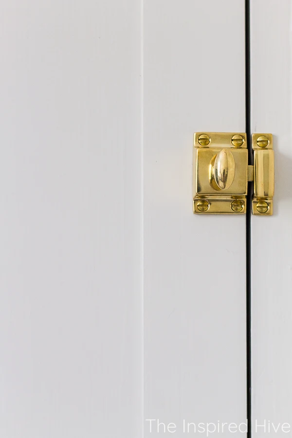 Unlacquered brass latch in vintage style on shaker cabinet door