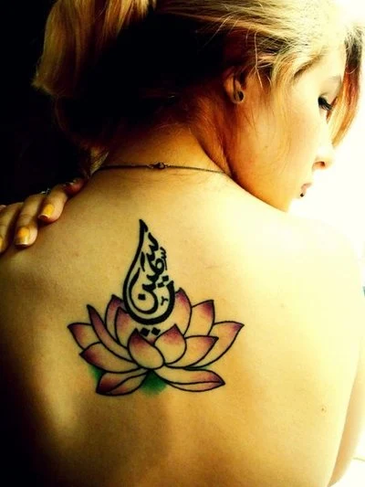 chica de espaldas con tatuaje de flor del loto en la espalda