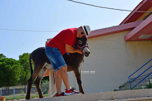 Άνδρας αγκαλιάζει ένα γαϊδούρι