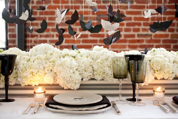 The table centerpiece is overflowing with gorgeous white bouquets while