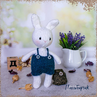 вязаная шерстяная игрушка белый заяц кролик в комбинезоне и с рюкзаком knitted wool toy white hare rabbit in overalls and with a backpack