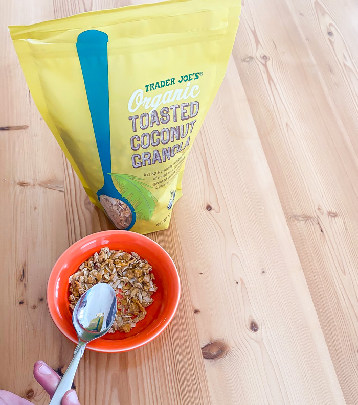 Trader Joe's coconut granola on table with bowl and spoon