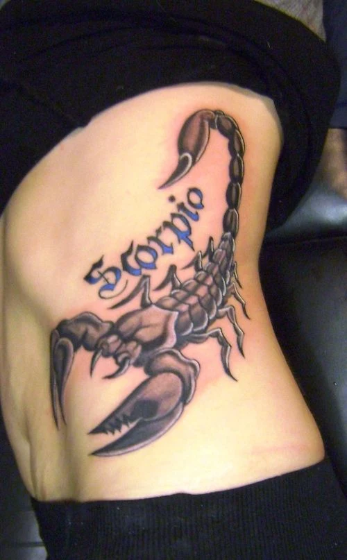 vemos una enseñando sus costillas, en ellas un tatuaje de escorpion que ls cubre totalmente