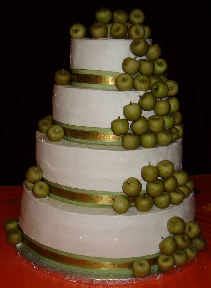 Unique four tier wedding cake with green apples cascading down the cake 