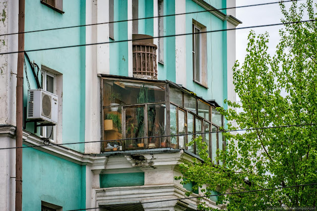 Застекленный балкон на фасаде ажурного здания