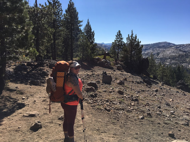 woman wearing a backpack on a mountain trail