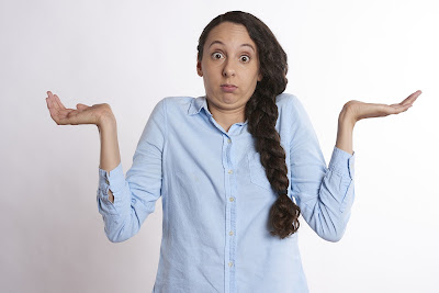 Lady in blue with tied hair looks confused