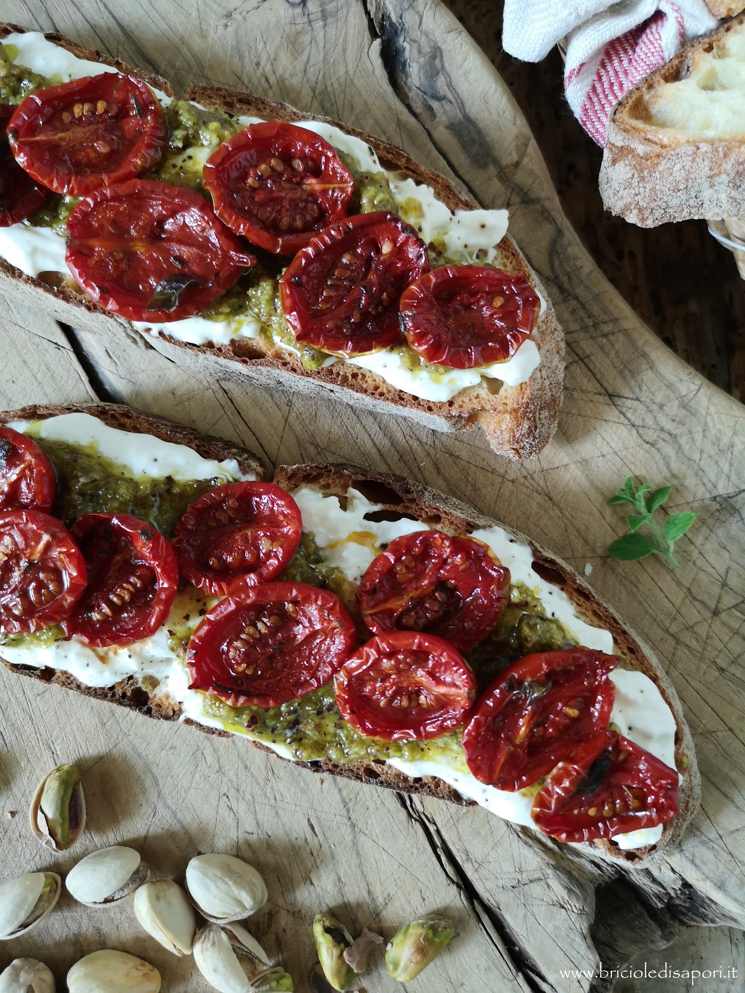 crostoni rustici con stracciatella pesto di pistacchi e pomodorini confit