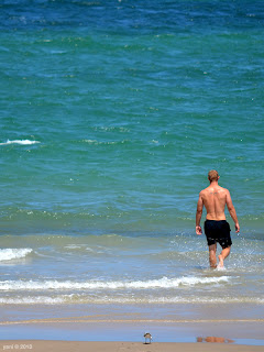 tattooed blonde walks into the ocean