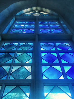 blue patterned stained glass window in die alte kirche, or the old st. mary's stone church in fredericksburg, texas
