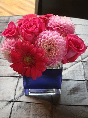 Centerpieces of gerber daisies dahlias roses hydrangea placed in cube 