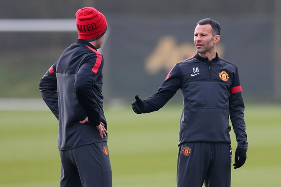 Ryan Giggs talks with a Manchester United teammate during a training session at Carrington