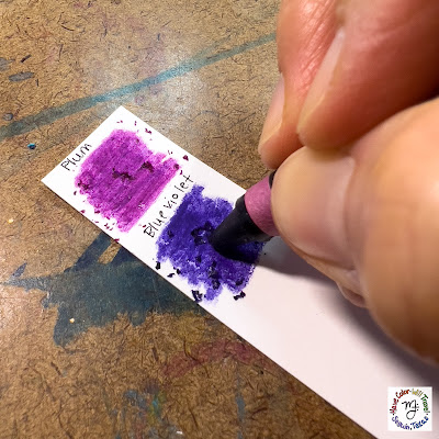 A couple of swatches of purple-ish crayon color are being colored close up.